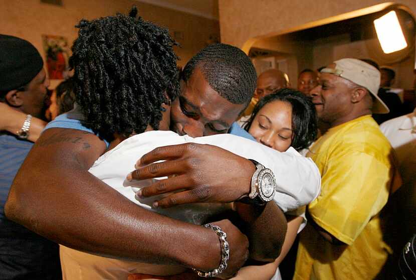 Oklahoma State wide receiver Dez Bryant, center, hugs his mother, Angie Bryant, after being...