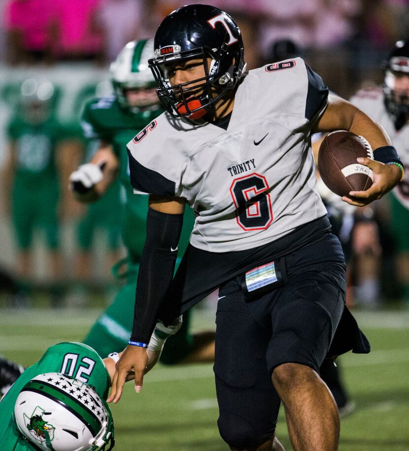 Euless Trinity quarterback Malini Maile (6) runs through a tackle attempt by Southlake...