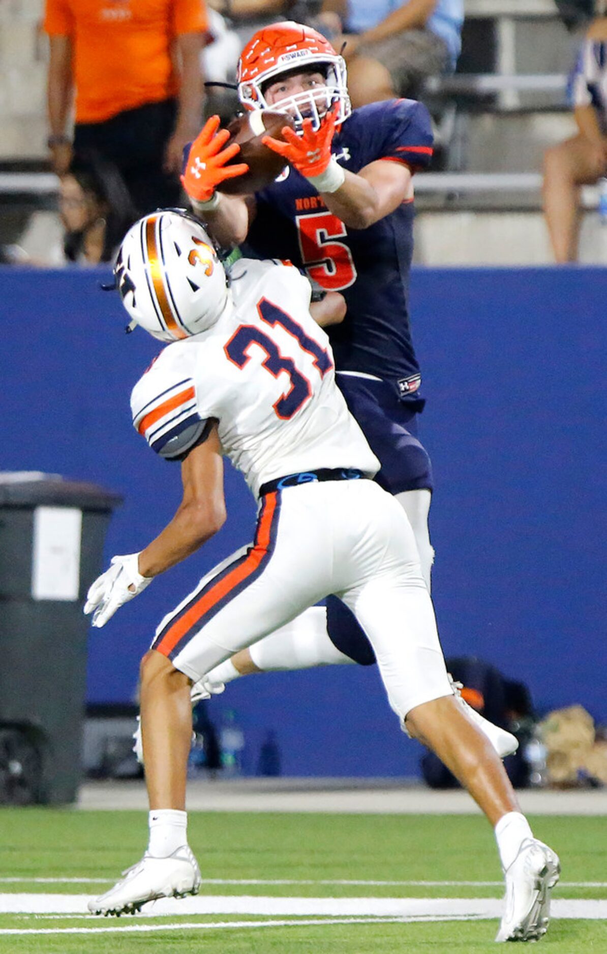 McKinney North High School wide receiver Brandon Frazier (5) goes high over Wakeland High...