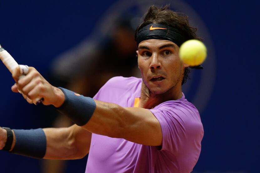 Spanish tennis player Rafael Nadal returns a ball to Argentinian David Nalbandian during the...