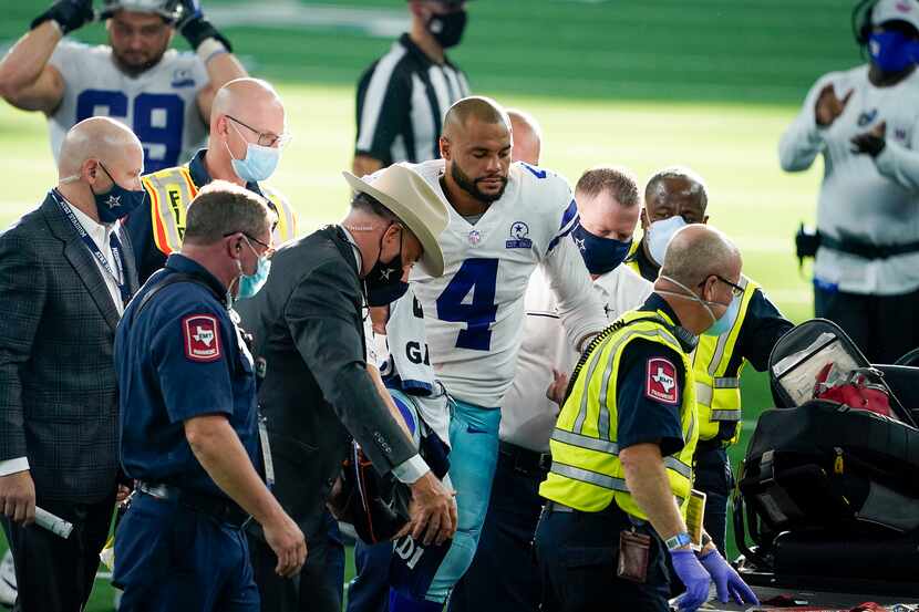 Cowboys quarterback Dak Prescott leaves the field on a cart after being injured on a tackle...