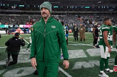 New York Jets quarterback Aaron Rodgers walks off the field after an NFL football game...