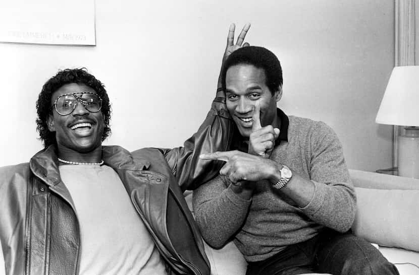 FILE - Former football player O.J. Simpson, right, clowns around with Los Angeles Rams...