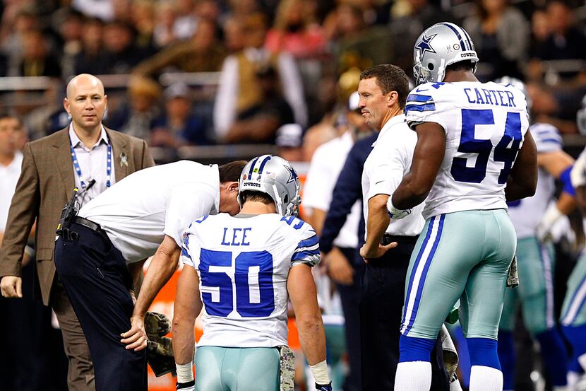 Trainers check on Dallas Cowboys middle linebacker Sean Lee (50) after being injured in the...