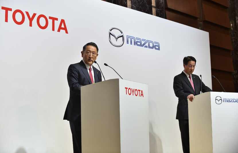 Toyota Motor Corporation President Akio Toyoda (L) answers questions as Mazda Motor...