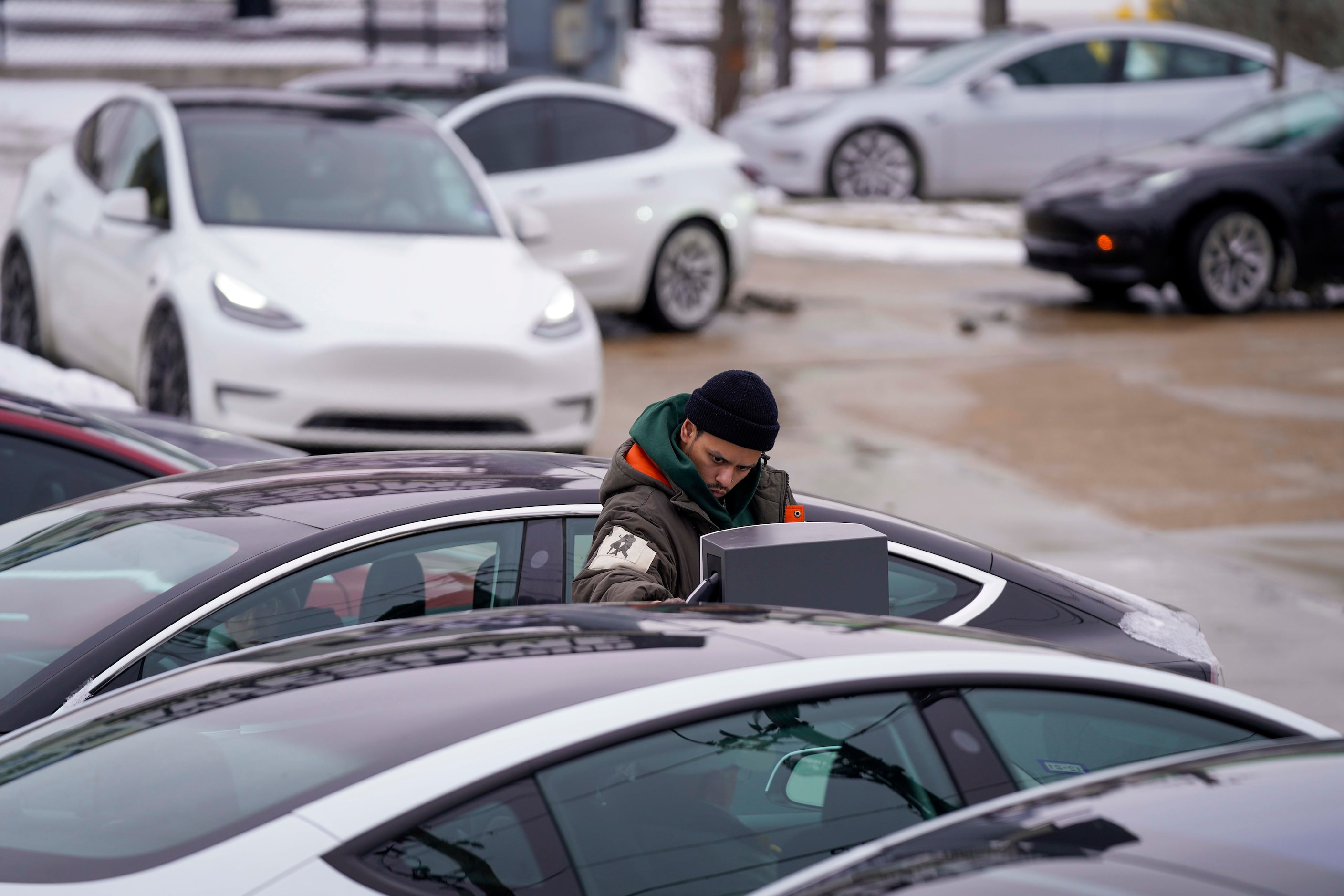 A line of cars waits for a charging station at the Tesla Supercharger on North Central...