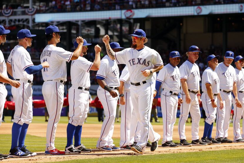 Texas Rangers left fielder Josh Hamilton (32) fist bumps teammates after being introduced...