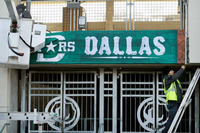 Edgar Pena (right) and Giovani Morales hang a Dallas Stars banner outside the Cotton Bowl in...