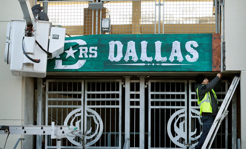 Edgar Pena (right) and Giovani Morales hang a Dallas Stars banner outside the Cotton Bowl in...