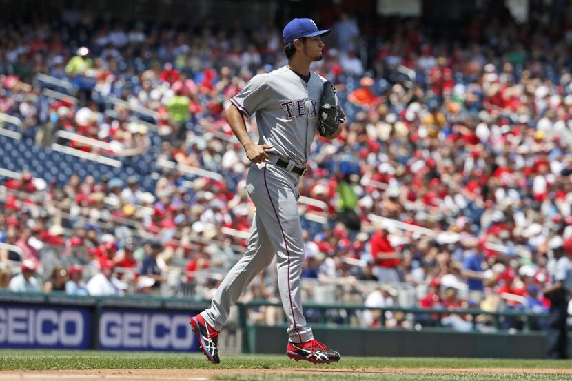 Texas Rangers starting pitcher Yu Darvish (11) jogs out to throw during the first inning of...