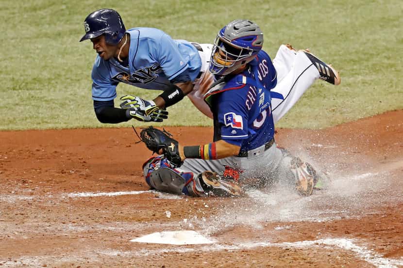 Tampa Bay Rays' Adeiny Hechavarria collides with Texas Rangers catcher Robinson Chirinos...