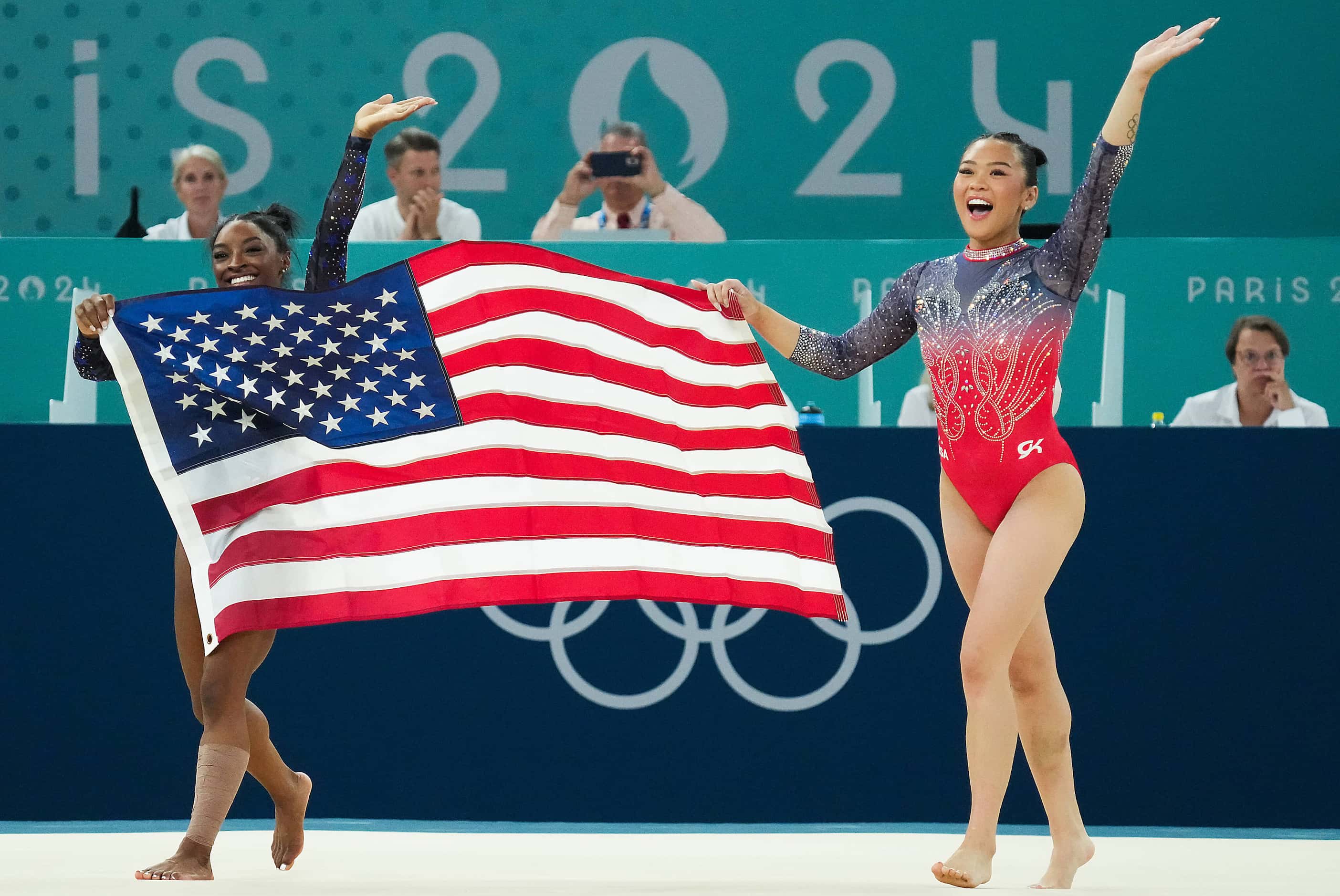 Simone Biles (left) and Suni Lee of the United States celebrate after winning the gold and...