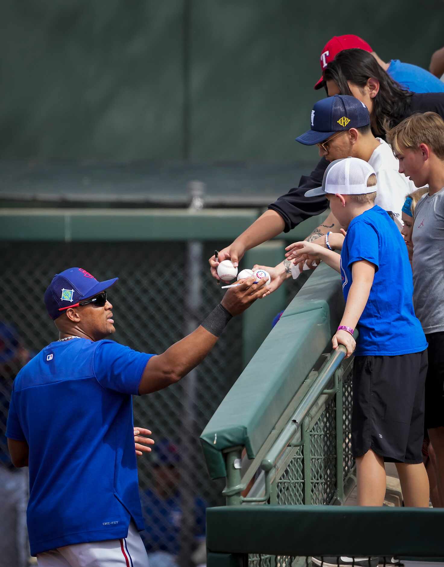 Former Texas Rangers third baseman Adrian Beltre signs autographs for fans during a spring...