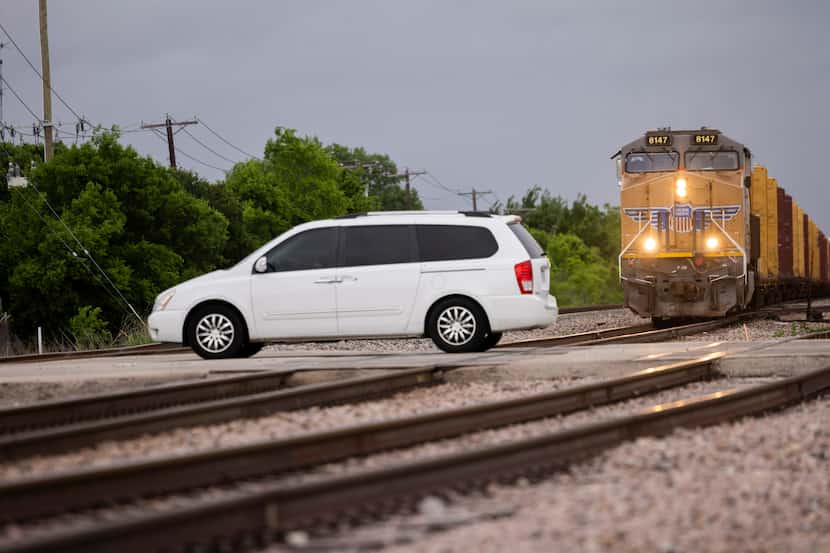 Un automóvil cruza las líneas del ferrocarril en la intersección de las vías con Jefferson...