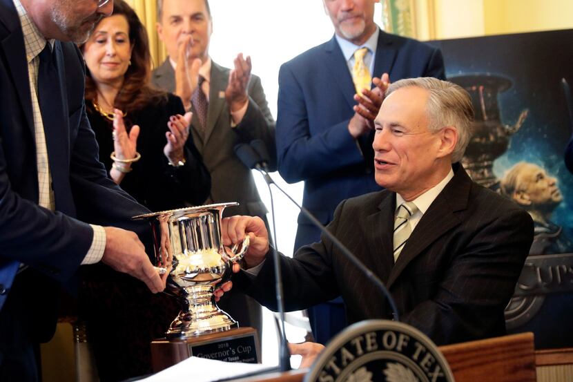 Texas Gov. Greg Abbott, right, is presented the Governor's Cup by Site Selection Magazine...