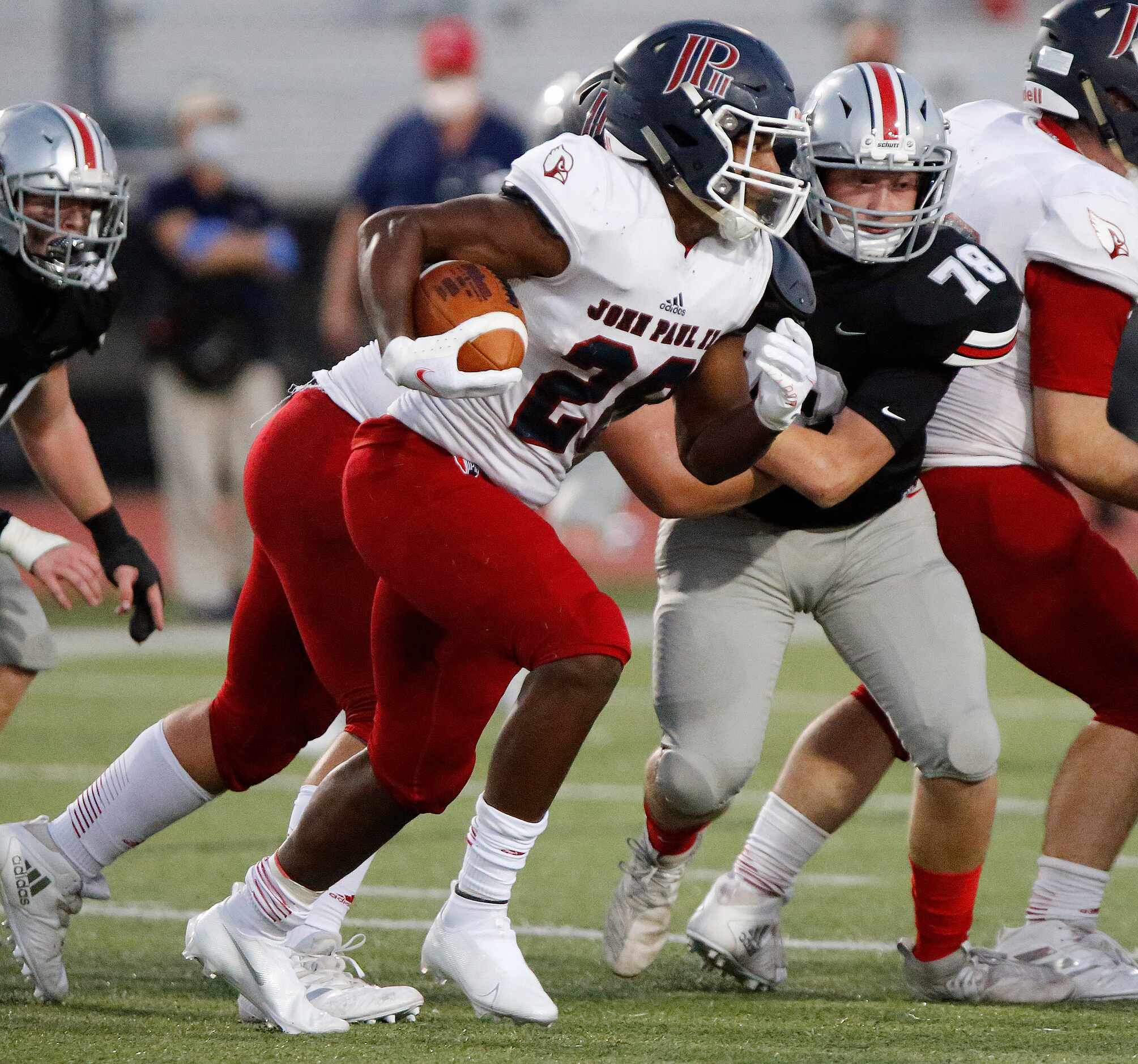 John Paul II High School running back Grant Robinson (28) runs behind his blocking for...