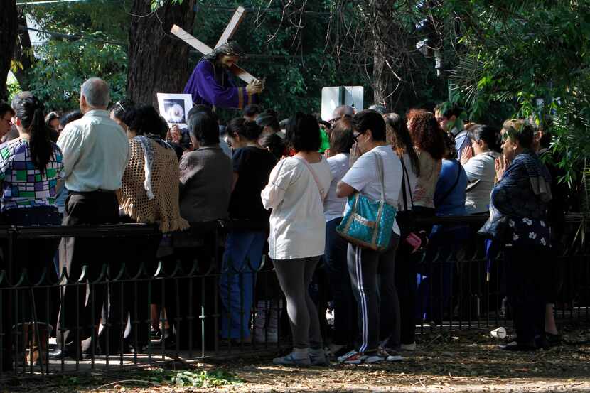 People who were participating in a Holy Week procession stop and pray after a strong...