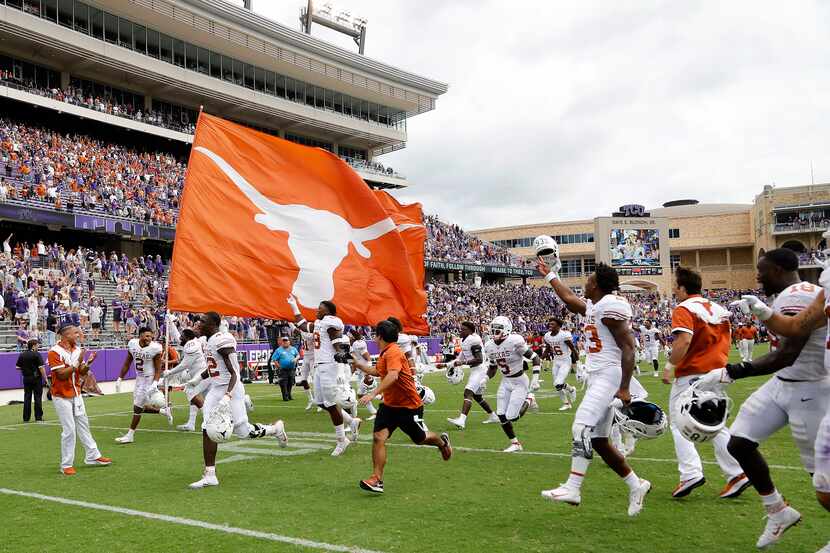 The Texas Longhorns take the field with a spirit flag after their victory as the TCU Horned...