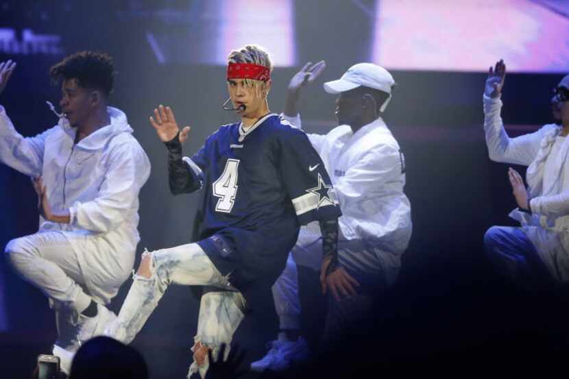Justin Bieber performs with his crew onstage at American Airlines Center in Dallas, Sunday,...