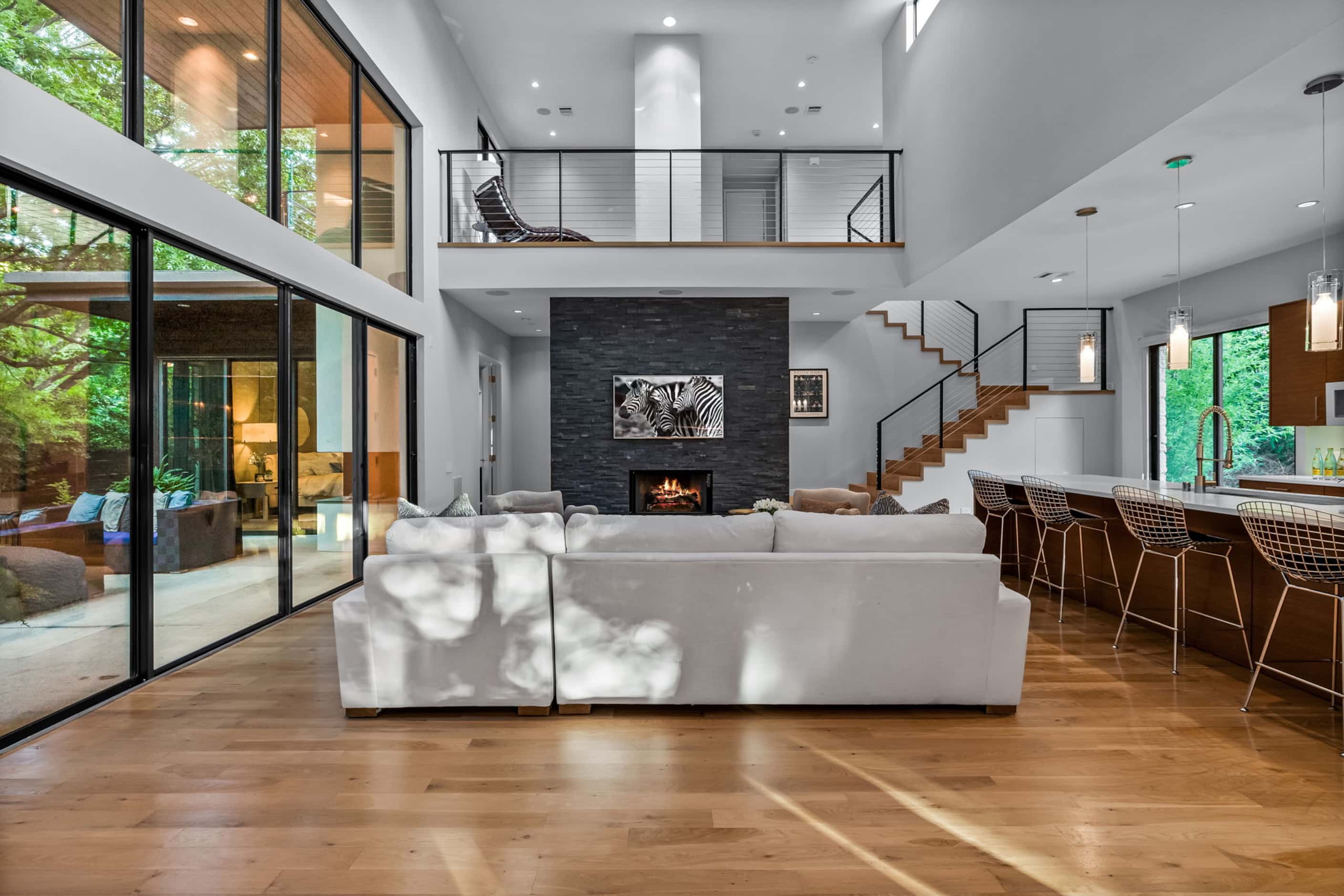 Two-story living room with open-concept design and a landing above that overlooks the...