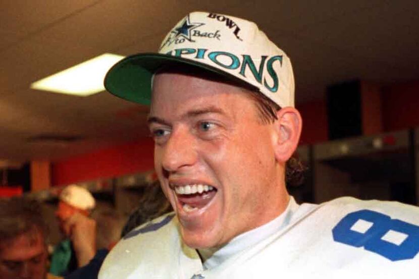 Cowboys quarterback Troy Aikman shows his excitement in the locker room following their win...