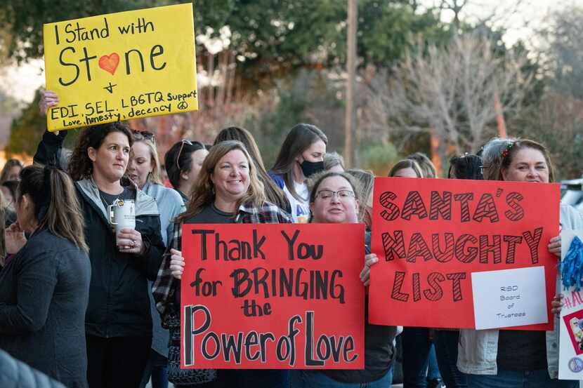 School counselor Heather Garrett holds a yellow sign that reads "I stand with Stone," along...