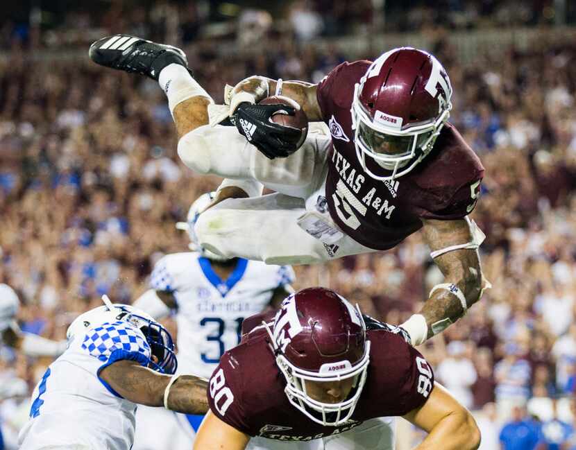 Texas A&M Aggies running back Trayveon Williams (5) is thrown in to the air as he runs to...