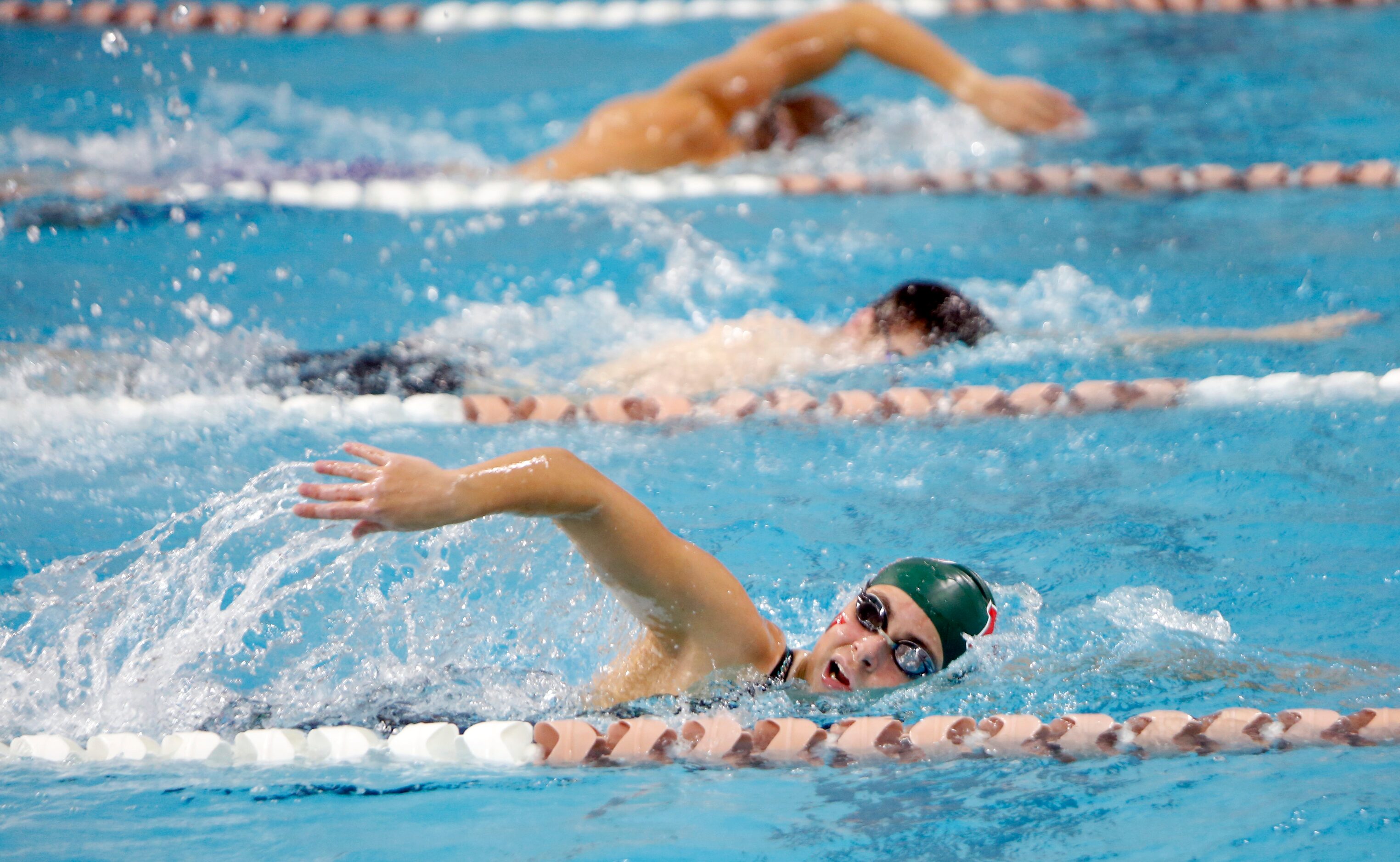 Swimmers warm up prior to 6A competition. The first day of the UIL state swimming and diving...