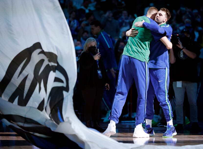 Dallas Mavericks guard Luka Doncic (right) receives a hug from center Kristaps Porzingis as...