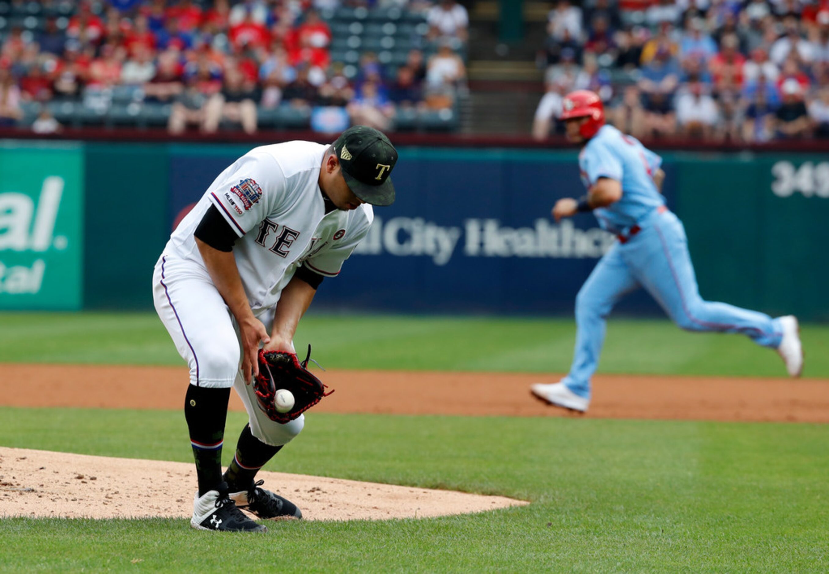 Texas Rangers relief pitcher Ariel Jurado reaches down to field a ground out by St. Louis...