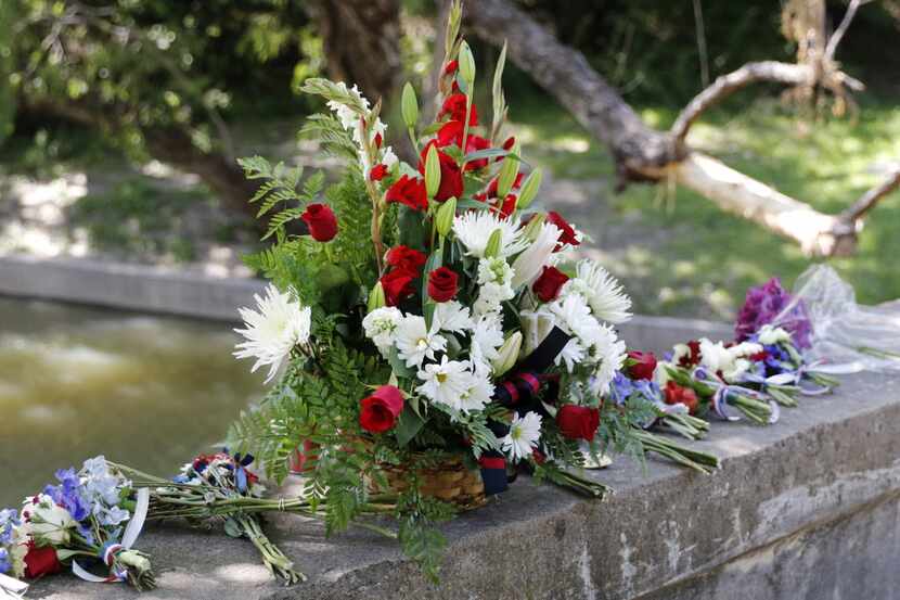 Flowers and candles were placed on a bridge at Stonebridge Drive on Turtle Creek as a...