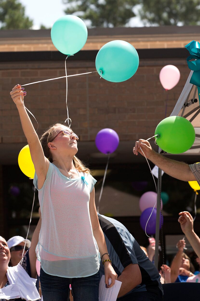 Cassidy Stay, the lone survivor of a family massacre in Texas, lets a balloon go during a...