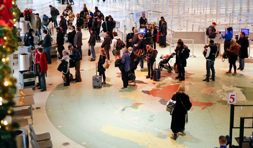 Travelers wait in line at a TSA security checkpoint at Dallas Love Field, where flights were...