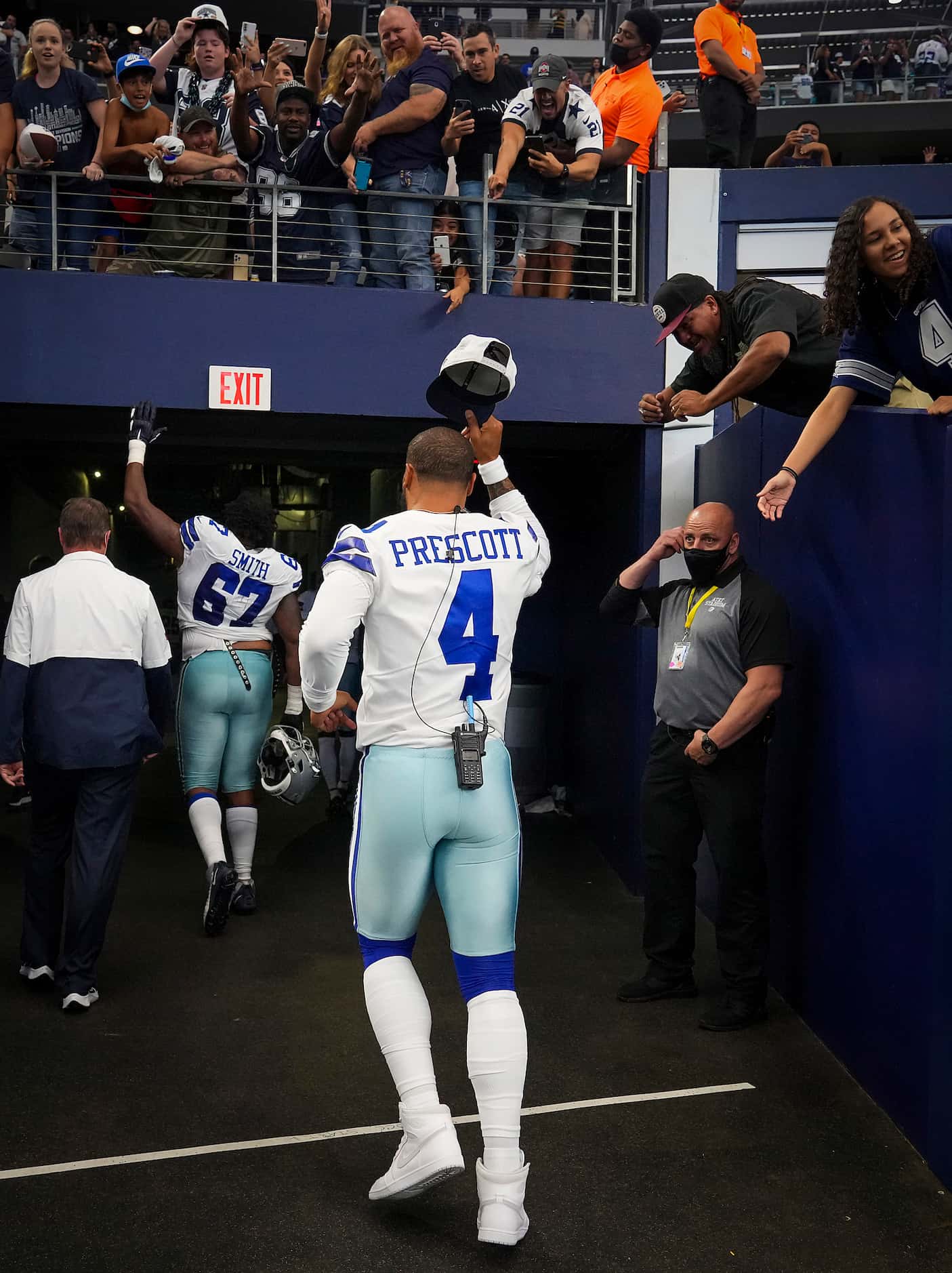 Dallas Cowboys quarterback Dak Prescott tosses his cap to the crowd as he leaves the field...