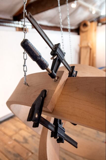 Clamps hold together curved pieces of wood in one of artist Rick Maxwell's unfinished...