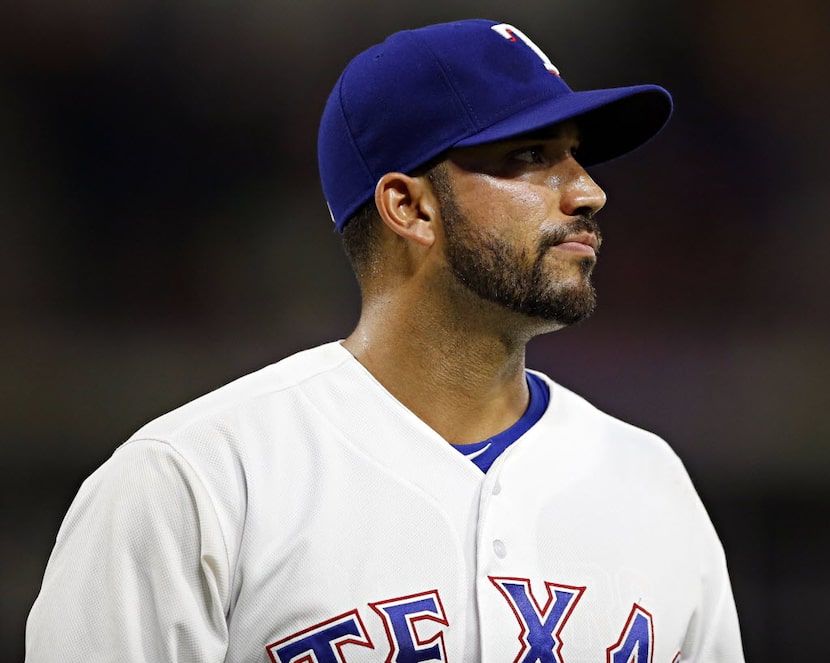 Texas Rangers relief pitcher Matt Bush walks back to the dugout dejected after surrendering...