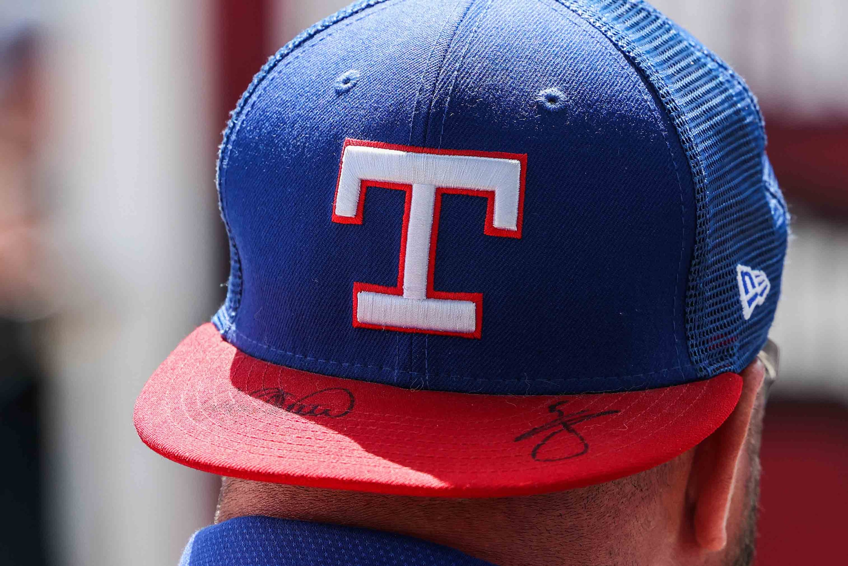 A fan wears a Texas Rangers hat before the game between Texas Rangers and Toronto Blue Jays...