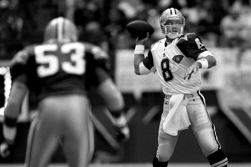 1/8/95--Dallas' QB Troy Aikman (8) looks downfield to pass as Green Bay LB George Koonce...