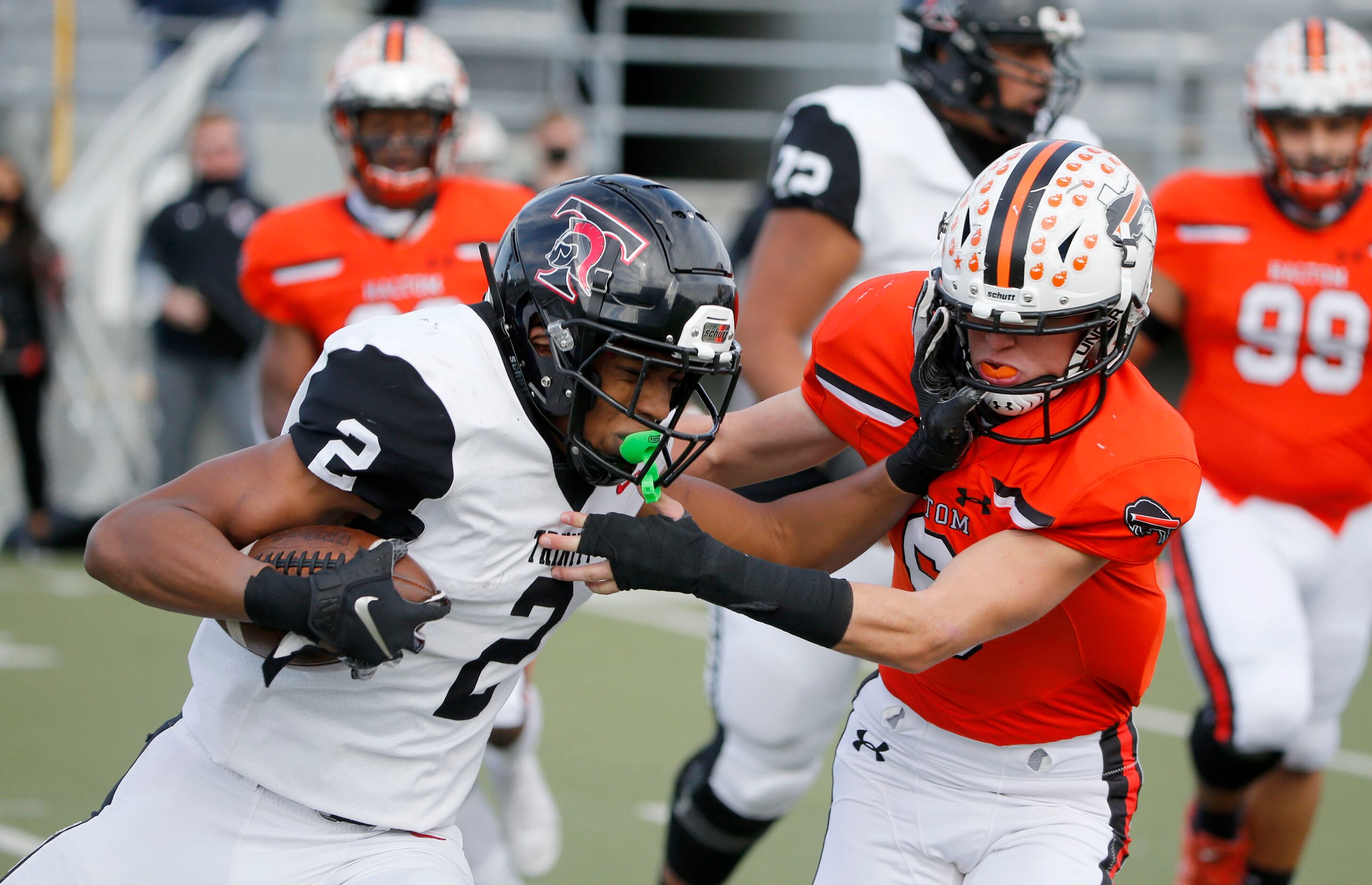 Euless Trinity running back Ollie Gordan (2) is tackled for a loss by Haltom safety Aaron...