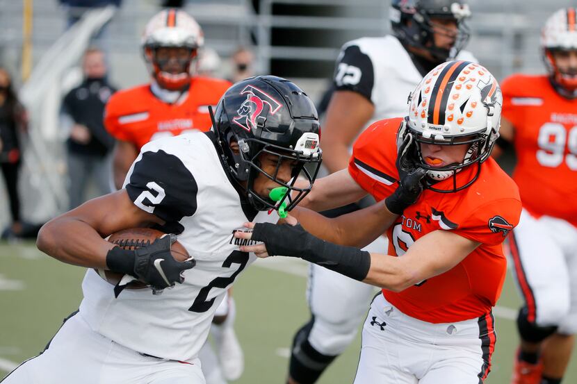 Euless Trinity running back Ollie Gordan (2) is tackled for a loss by Haltom safety Aaron...