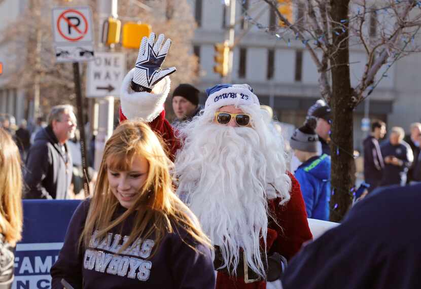 Ray White, dressed as Santa Claus, greets fans as they arrive outside the stadium before the...