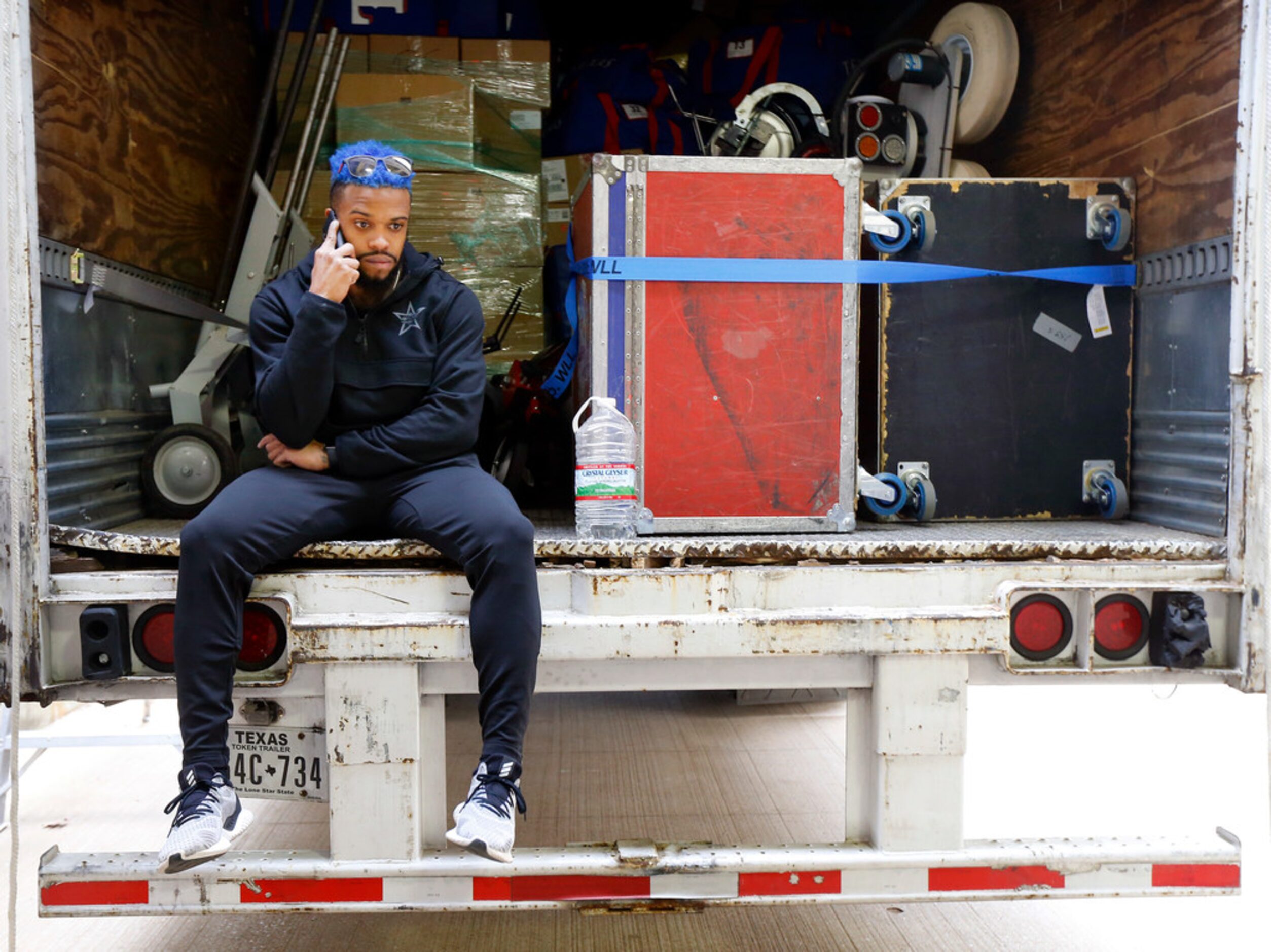 Texas Rangers outfielder Delino DeShields sports blue hair while sitting on the back of the...