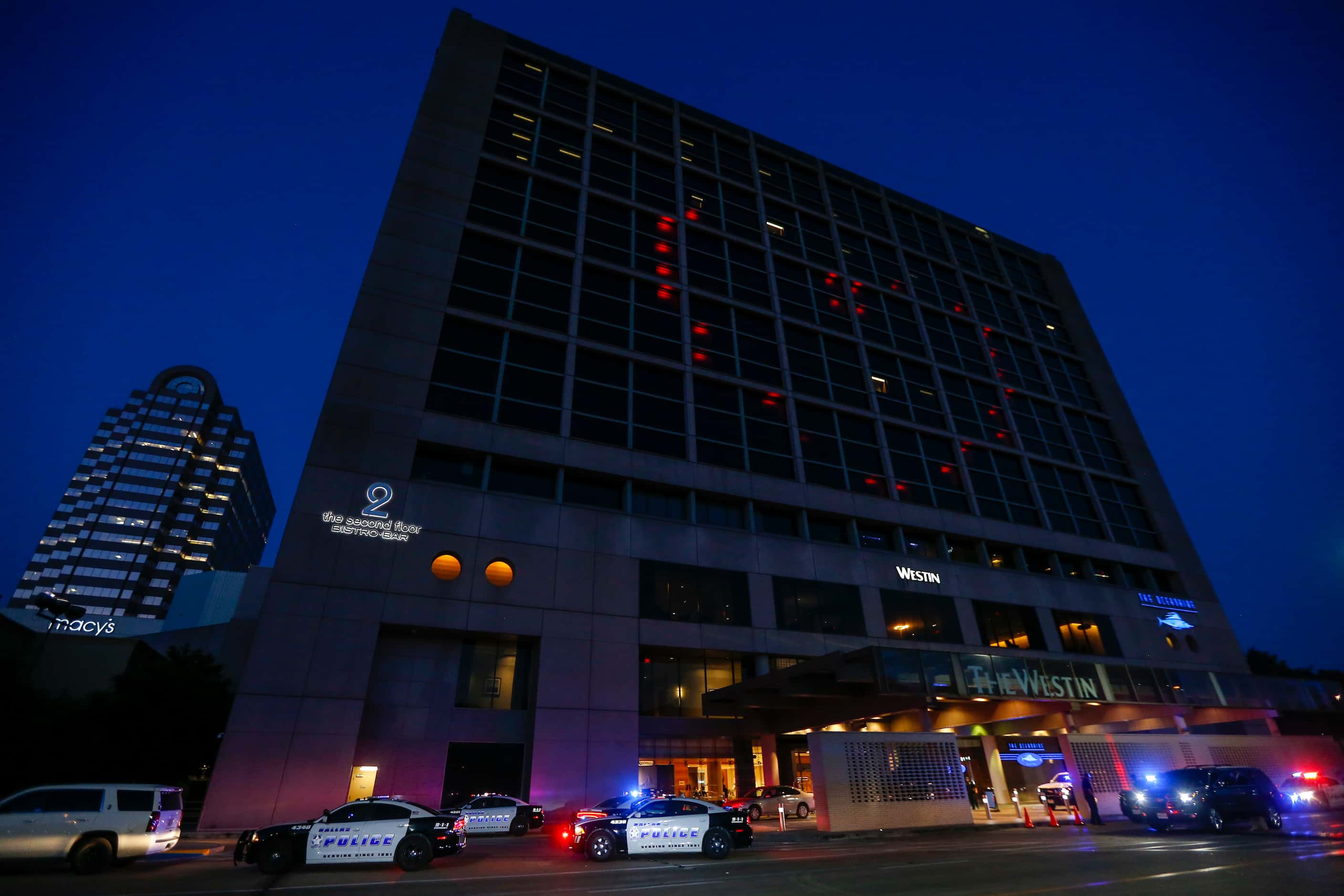 A red heart is highlighted by windows of the Westin Hotel as police work below at the...