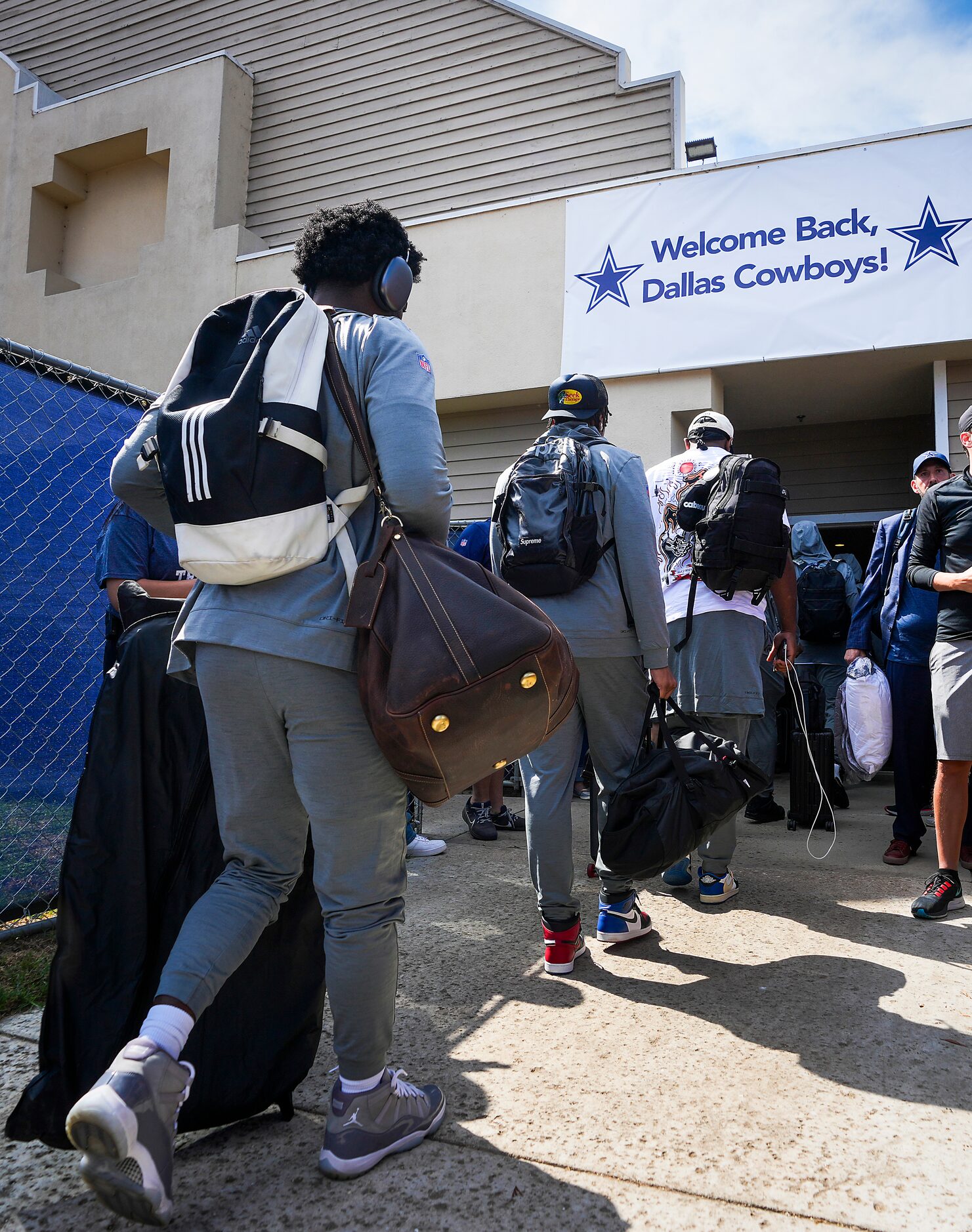 Dallas Cowboys players head inside their hotel as the team arrives for training camp on...