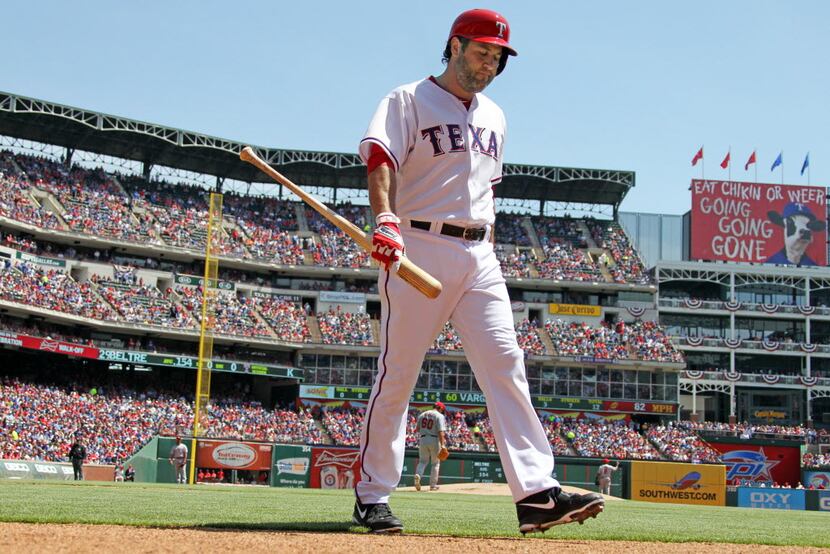 Texas' Lance Berkman walks back to the dugout after striking out in the first inning during...