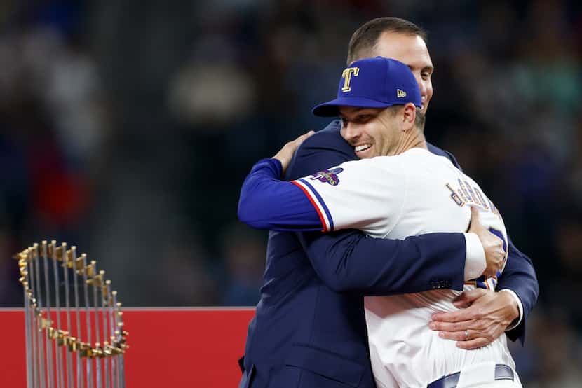 Texas Rangers general manager Chris Young hugs starting pitcher Jacob deGrom as he’s...