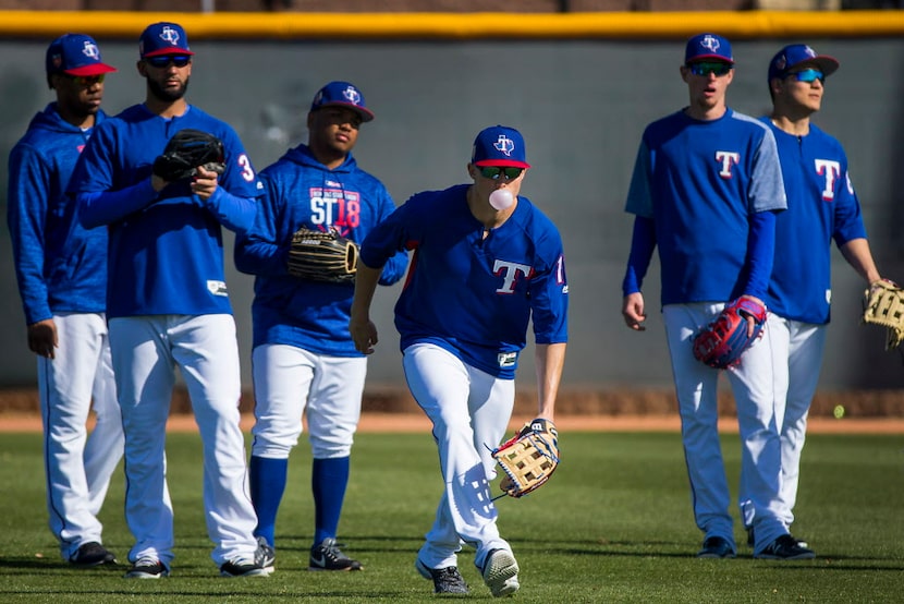 10:10 AM -- Drew Robinson blows a bubble while taking fielding practice with teammates, from...