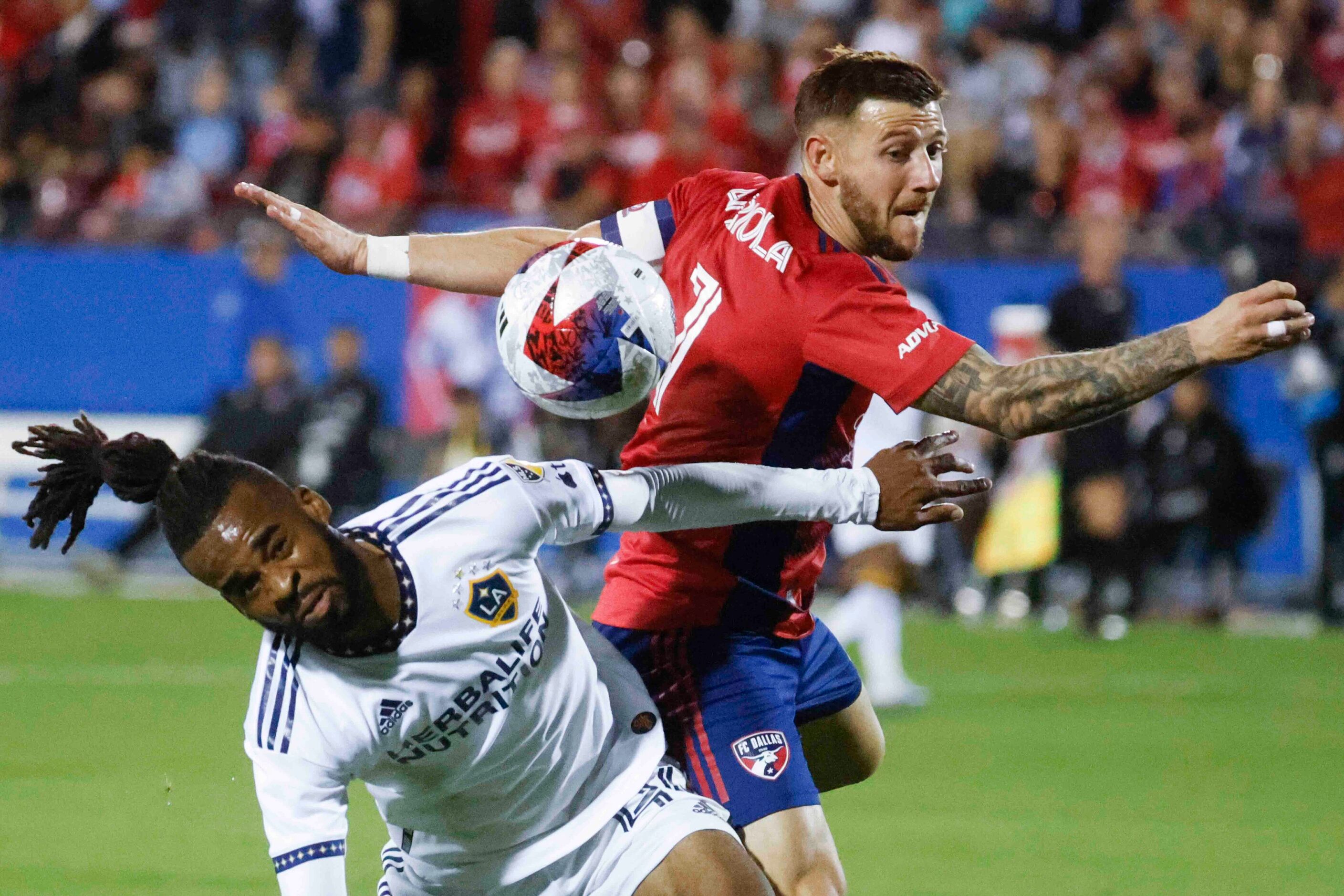 Los Angeles Galaxy forward Raheem Edwards (left) and FC Dallas forward Paul Arriola fights...