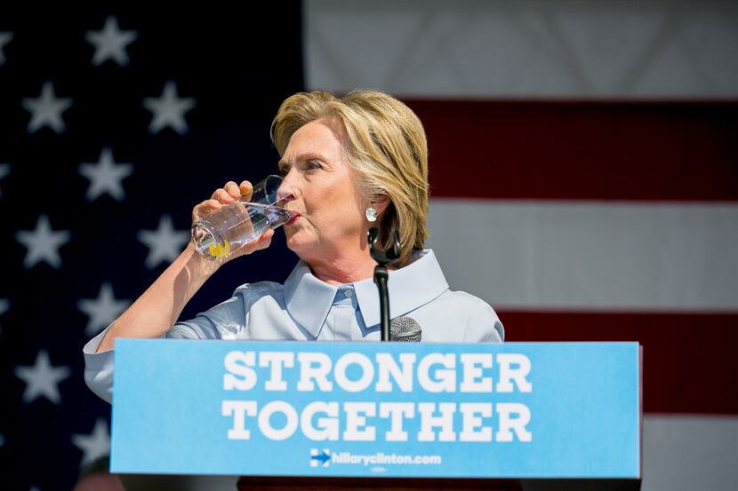 Hillary Clinton, the Democratic presidential nominee, takes a drink of water after coughing...
