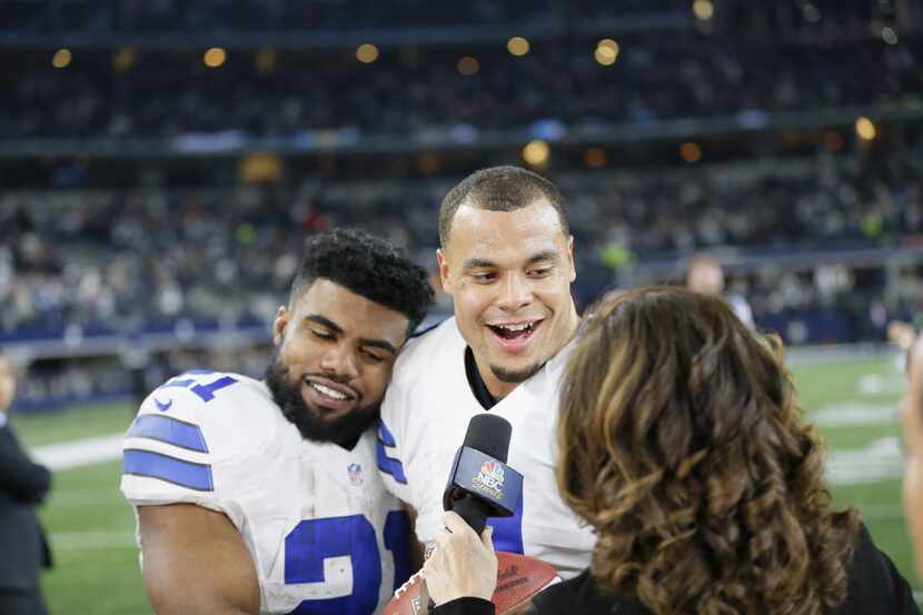 Dallas Cowboys' Ezekiel Elliott, left, and Dak Prescott, center, joke around as they give an...